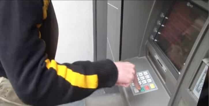 Un homme utilise un distributeur de billet.