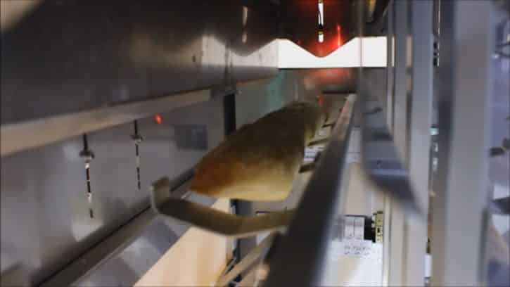 Une baguette est acheminée dans la machine de Bread Xpress