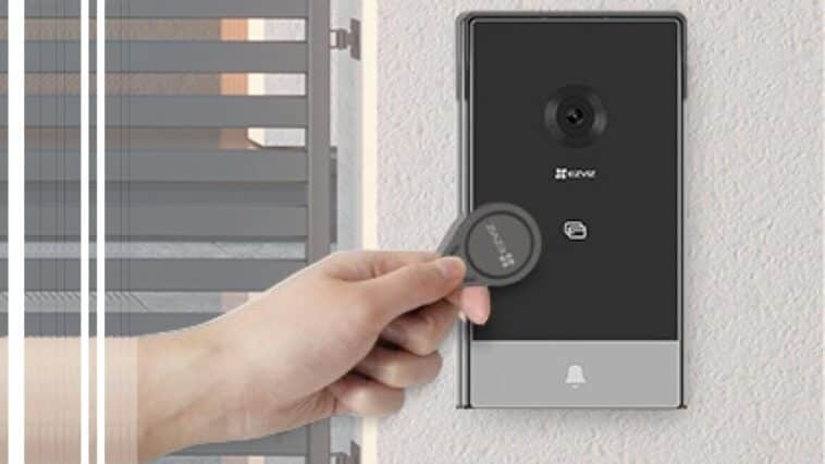 Gros plan sur la main d'une personne en train d'utiliser le visiophone connecté EZVIZ CP7, fixé près d'un portail