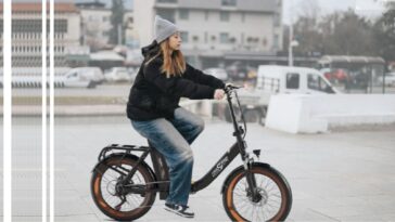 Photo d'une jeune fille sur un vélo électrique en plein centre ville