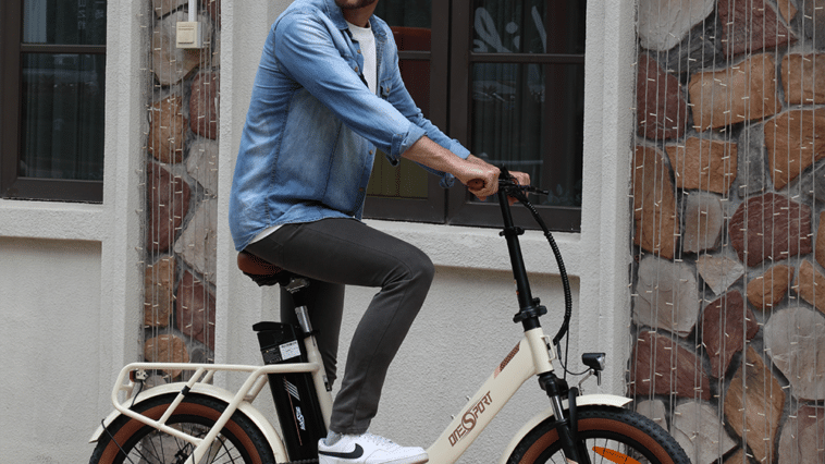 Un jeune homme sur le vélo pliable OneSport Global OT16