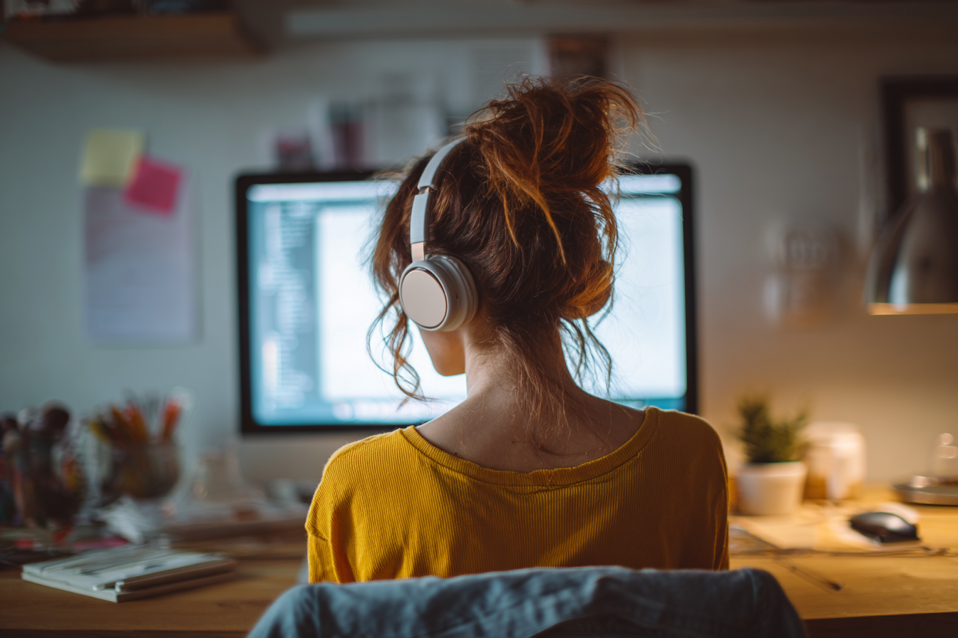 Femme en télétravail concentrée devant un PC silencieux et ultra-performant, dans un espace de travail épuré et calme.
