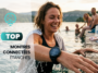 Femme souriante sortant de l'eau avec une montre connectée étanche de natation au poignet.