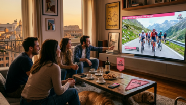 Groupe d'amis regardant une étape de cyclisme du Giro d'Italia à la télévision dans un salon à Rome au coucher du soleil.