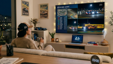 Personne suivant en direct les 24 Heures du Mans sur un grand écran de télévision avec les classements de la course.