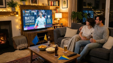 Couple regarde un match de football à la télévision dans un salon chaleureux.