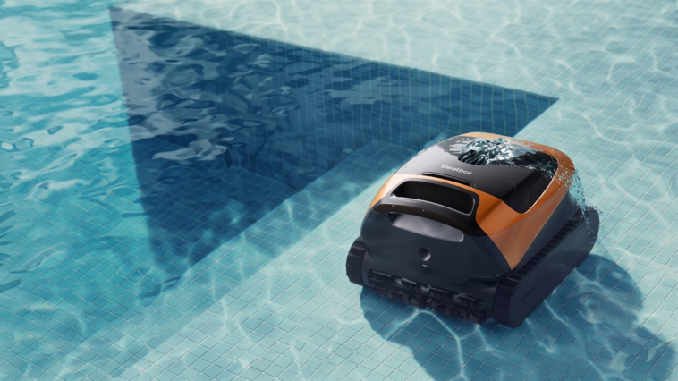 Le robot nettoyeur de piscine sans fil Beatbot Sora 30 orange et noir en train de se déplacer au fond de l'eau claire d'un bassin carrelé.