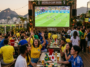 Foule joyeuse dans un bar en terrasse regardant un match de la Coupe du Monde 2026 entre le Brésil et le Japon