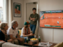 Famille et amis regardant ensemble la finale de Roland-Garros 2026 à la télévision dans un salon.