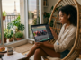 Une jeune femme regarde une course de MotoGP sur une tablette depuis son appartement à Paris avec vue sur la Tour Eiffel.