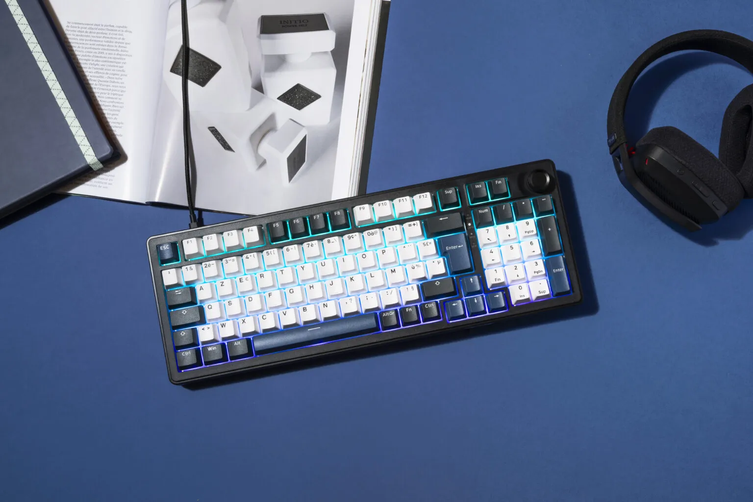 Clavier gamer magnétique KEYZ ELITE 400 HE avec rétroéclairage RGB activé, posé sur un bureau bleu.