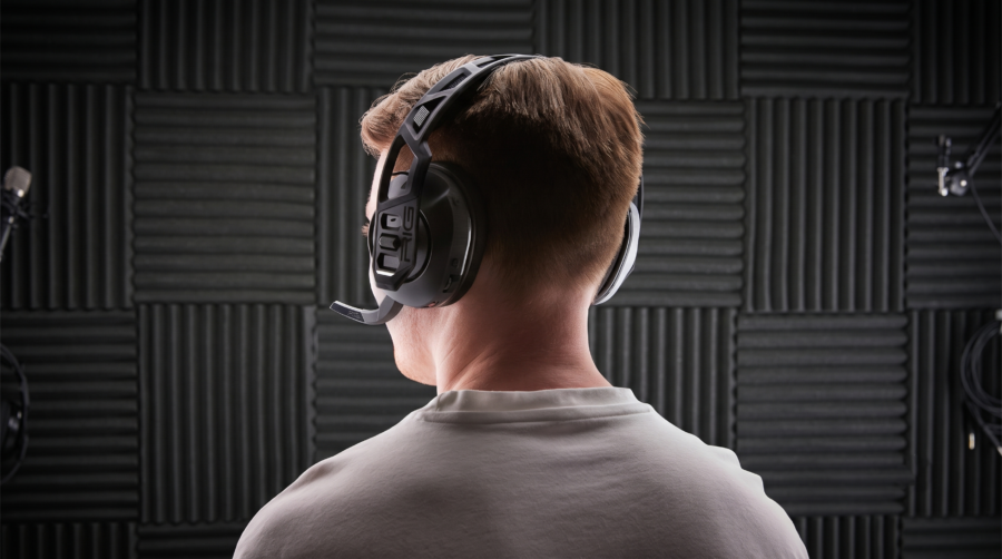 Homme vu de dos portant le casque gaming Nacon RIG 600 PRO HS dans un studio acoustique.