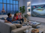 Amis regardant un match de football Norvège vs France de la Coupe du Monde 2026 dans un salon avec vue sur la Tour Eiffel.