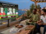 "Deux hommes regardant un match de la Coupe du Monde 2026 entre le Sénégal et l'Irak sur grand écran