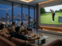 Amis installés dans un salon moderne avec vue sur la ville regardant le tournoi de golf US Open 2026 sur grand écran
