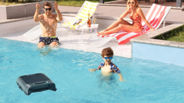 Le robot skimmer de piscine solaire Aiper EcoSurfer S2 flottant dans l'eau d'une piscine ensoleillée avec une famille en arrière-plan.