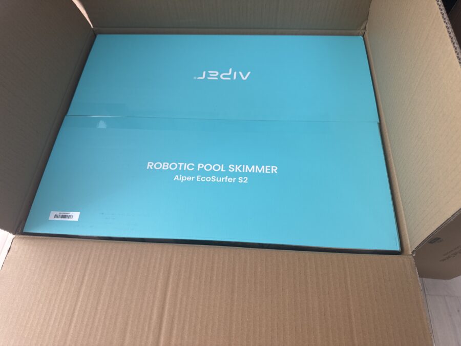 La boîte turquoise du skimmer de piscine Aiper EcoSurfer S2 dans son carton de transport.