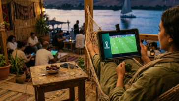 Personne regardant le match de football Australie VS Egypte sur une tablette tout en se relaxant dans un hamac au bord de l'eau.