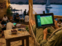 Personne regardant le match de football Australie VS Egypte sur une tablette tout en se relaxant dans un hamac au bord de l'eau.