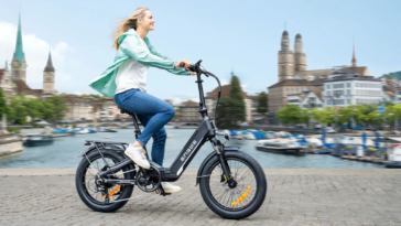 Femme circulant en ville au bord de l'eau sur le vélo électrique ENGWE L20 3.0 Boost.