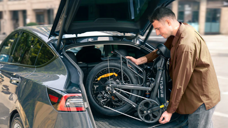 Un homme chargeant le vélo électrique plié ENGWE L20 3.0 Boost dans le coffre d'une voiture.