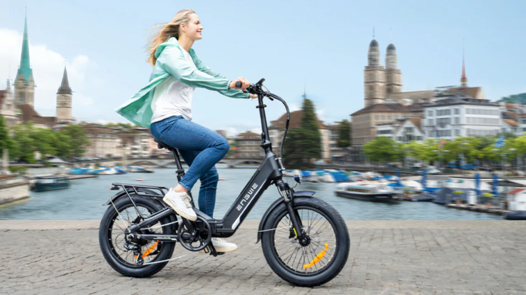 Femme circulant en ville au bord de l'eau sur le vélo électrique ENGWE L20 3.0 Boost.