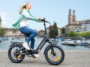 Femme circulant en ville au bord de l'eau sur le vélo électrique ENGWE L20 3.0 Boost.