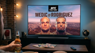 Un fan regarde l'UFC Fight Night : Medic vs Rodriguez à la télévision avec une bière à la main, un gant de boxe à proximité et l'horizon d'Austin sur l'écran