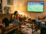 Amis regardant un match de football entre le Portugal et l'Espagne confortablement installés dans un salon.