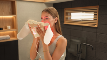 Une femme utilisant le masque de soin LED Renpho ARTEMIS.