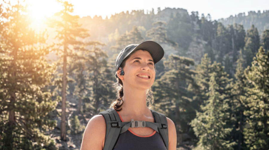 Femme en randonnée dans une forêt avec le casque Runner Diver2 Pro.