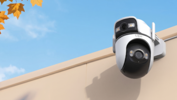 Caméra de surveillance Tapo TC47 installée sur un mur avec feuilles d'automne et ciel bleu.