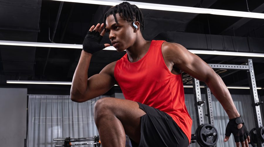Un homme faisant du sport tout en écoutant de la musique avec les écouteurs Shokz OpenFit Air 2.