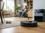 Un des aspirateurs robots hybrides de 2026 nettoie un parquet dans un salon lumineux près de sa station d'accueil.
