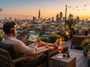 Un homme en chaise longue sur un toit-terrasse regarde une course sur sa tablette, face à la skyline de Londres au coucher du soleil.
