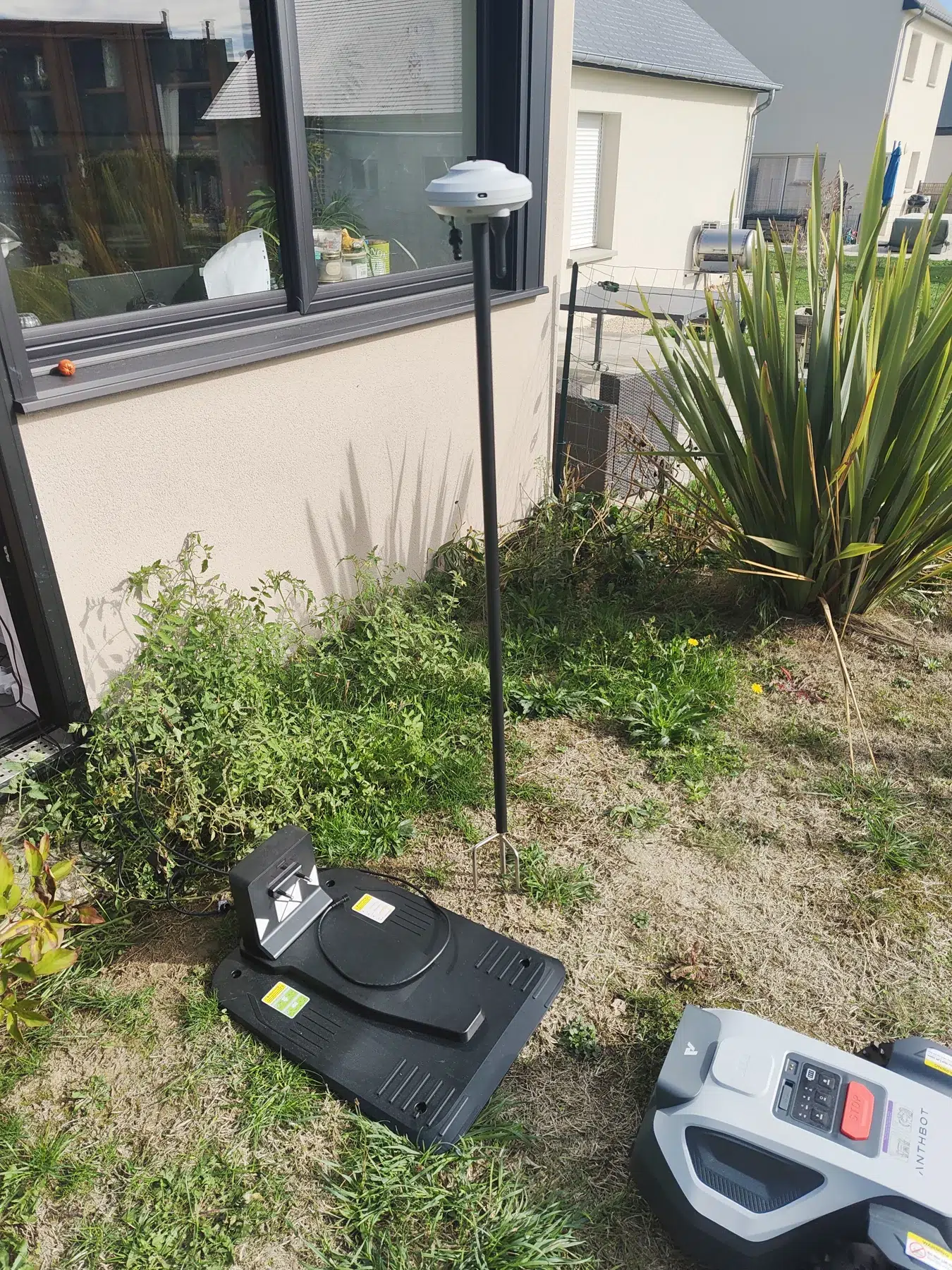 Antenne RTK sur son mât à côté de la station de recharge et du robot ANTHBOT M5